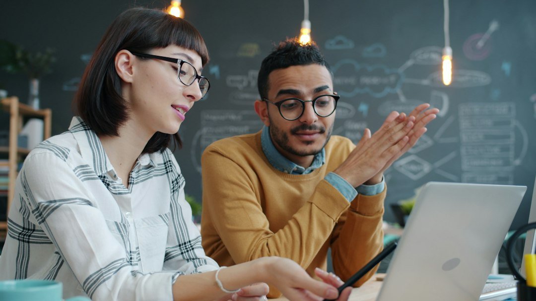 Two colleagues collaborating on a project at a laptop